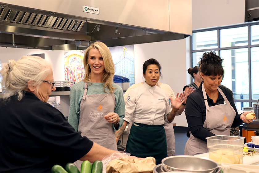 First Partner Jennifer Siebel Newsom joins school nutrition staff to chop potatoes.