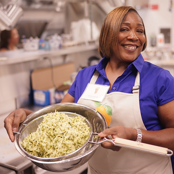 Donna shows off rice in colander